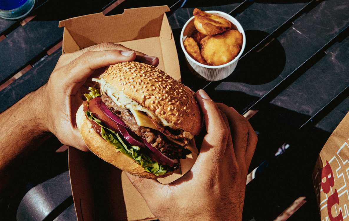 Hands holding a burger