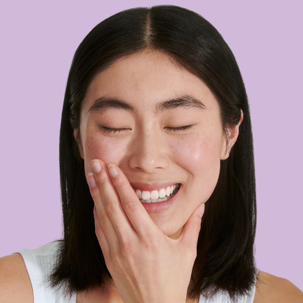Woman smiling touching her face